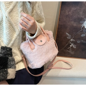 Détail d'un sac à main en fourrure rose montrant la texture douce et la bandoulière