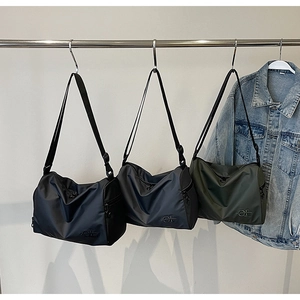 Trois sacs bandoulière en nylon noir, gris et vert montrant le tissu imperméable