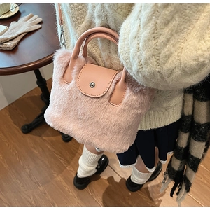 Sac à main en fausse fourrure rose avec poignée en cuir et fermoir en métal argenté