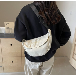 Detail of off-white dumpling bag with mountain line embroidery and wide strap