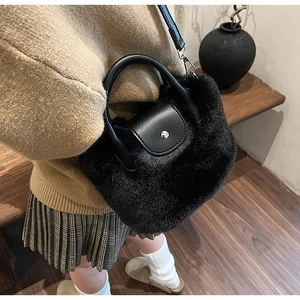 Détail du sac à main noir en fausse fourrure avec rabat en cuir et bouton argenté