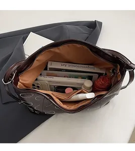 Detail view of large dark brown tote bag showing spacious interior with tablet and books