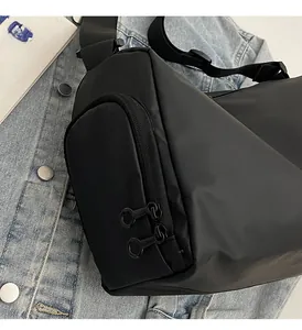 Gros plan du sac bandoulière noir en nylon avec double fermeture éclair et fini mat