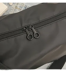 Détail d'un sac en nylon noir avec fermeture éclair double à anneaux métalliques