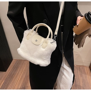 Sac à main en peluche blanche porté en bandoulière avec détails en cuir beige sur modèle