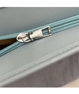 Close-up of light blue leather tote with a polished silver zipper and neat stitching