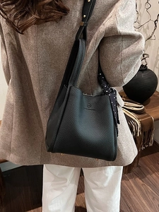 Chic black lychee grain bucket bag with silk scarf accessory and shoulder strap