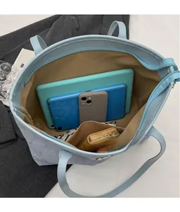 Interior view of large blue tote bag showing spacious storage for tablet and wallet