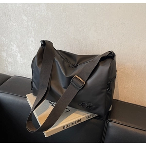 Détail du sac à bandoulière noir minimaliste en nylon avec double fermeture éclair