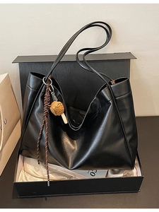 Classic black leather tote bag with braided charm and spacious design in a gift box
