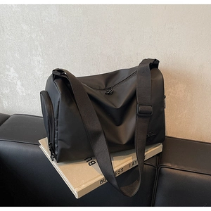 Détail du grand sac cabas noir en nylon avec bandoulière réglable et compartiment