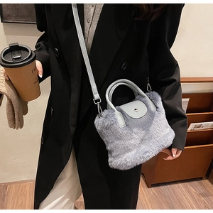 Vue détaillée du sac bandoulière en fausse fourrure bleu clair avec lanière en cuir sur modèle