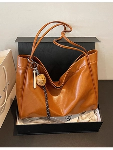 Deep brown leather tote bag with baseball charm in premium black gift box packaging