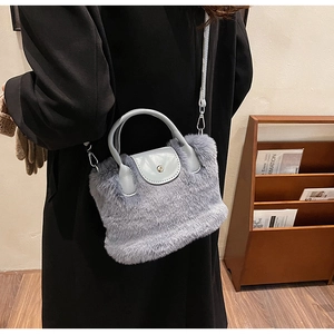 Détail du sac bandoulière en fausse fourrure bleu clair avec rabat en cuir sur modèle