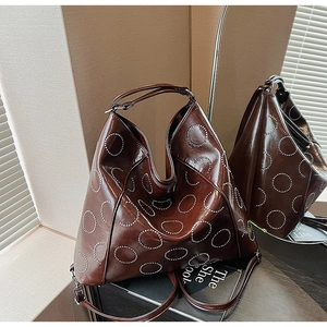 Detailed view of large dark brown hobo tote with metallic silver stud circular patterns