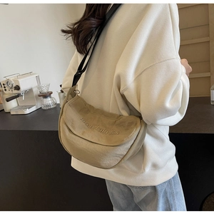 Detailed back view of a khaki canvas crescent bag with mountain line embroidery