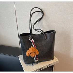 Dettaglio della borsa tote vintage grigio scuro con ciondolo a forma di barboncino
