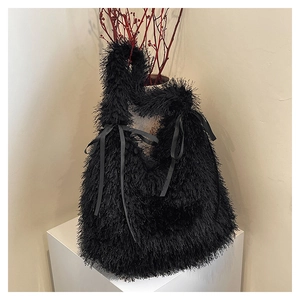 Detail of black faux feather tote bag featuring silk bows and soft fringe texture