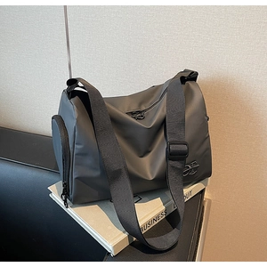 Détail du sac de voyage gris foncé durable avec bandoulière réglable et poche zippée