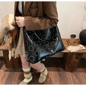 Macro shot of large black tote bag featuring distinctive white circular dot patterns