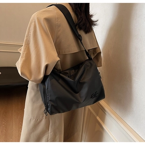 Détail du sac bandoulière en nylon imperméable avec large sangle et logo brodé