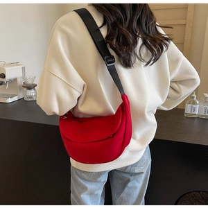 Detail of red canvas crossbody bag with mountain trip embroidery and wide shoulder strap