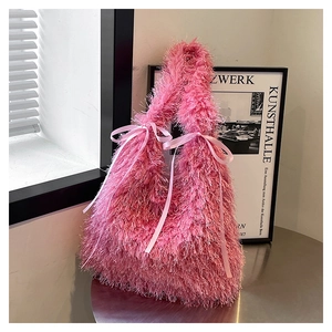 Detail of pink plush tote bag with tassel texture and satin ribbon bow accents