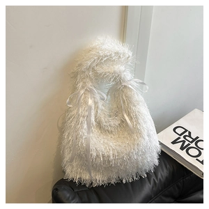 Close-up of white plush tassel tote bag with satin bow handles and fluffy texture