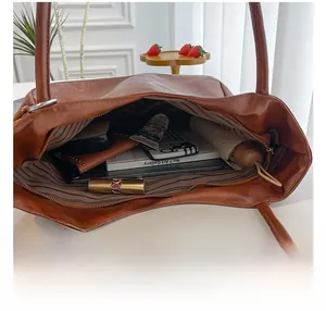 Dettaglio della grande capacità interna di questa borsa tote vintage in pelle marrone