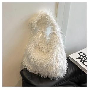 Detail of white faux fur tote bag with fluffy texture and decorative ribbon bow