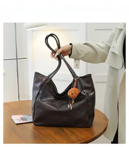 Vista dettagliata della borsa tote vintage marrone scuro con ciondolo a orsetto