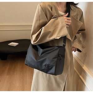 Détail du sac cabas en nylon mat noir avec broderie et large bandoulière réglable