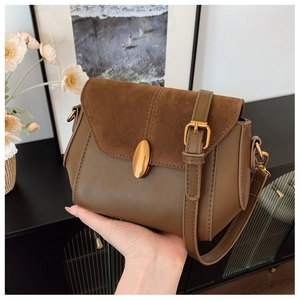 Detail of retro brown crossbody bag with gold buckle and suede texture flap