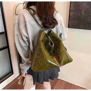Olive green high-gloss tote bag featuring geometric perforated patterns on a smooth surface