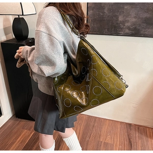 Detail of olive green tote bag with silver metal studs and wide shoulder strap