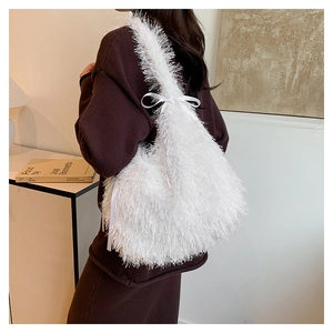 Detailed view of white faux fur tote bag with satin bow strap on female shoulder