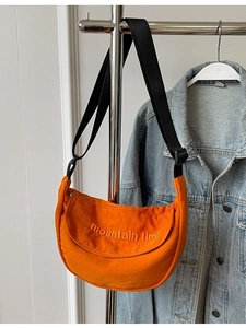Orange canvas half-moon crossbody bag with mountain line embroidery and black strap