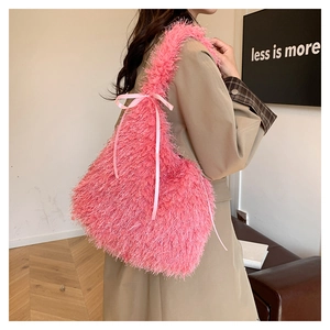 Detailed view of pink long faux fur tote bag with tassel trim and silky bow on beige coat