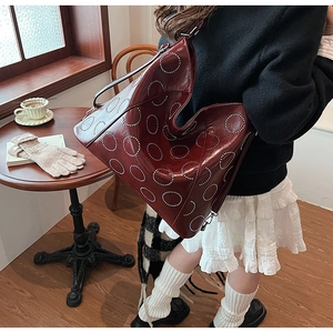 Deep burgundy tote bag featuring silver studs in circular patterns for a retro autumn style