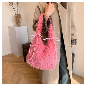 Detail of bright pink fluffy faux fur tote bag featuring sweet satin bows and soft texture