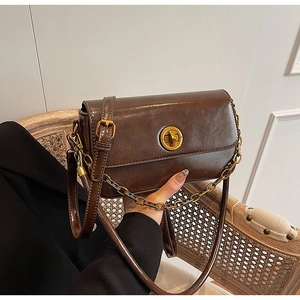 Detailed close-up of a vintage dark brown oil wax leather handbag with golden chain