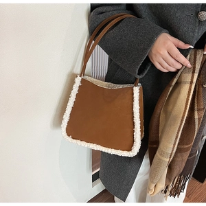 Brown suede tote bag with white faux fur trim and leather handles in a winter outfit look