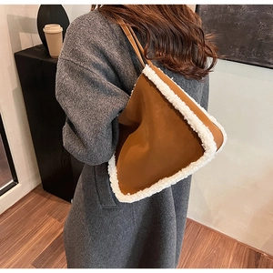 Detail of caramel leather underarm bag with white faux shearling trim and slim strap