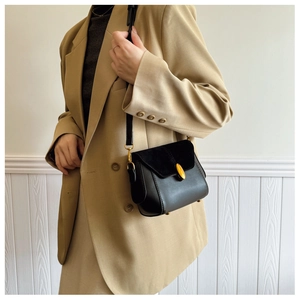 Detail of vintage black flap bag showing suede textures and amber resin buckle