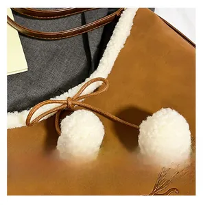 Close-up of brown faux leather bag featuring white fuzzy fleece trim and plush pom-poms