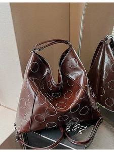 Brown leather hobo tote bag with silver studs and adjustable shoulder strap for women
