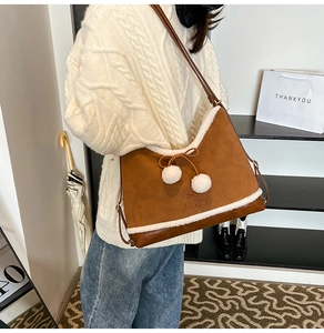 Close-up of brown PU leather shoulder bag with white faux fur trim and bow detail