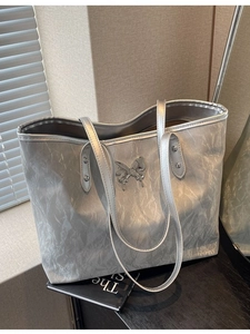 Metallic silver tote bag with crinkled texture and silver butterfly ornament detail