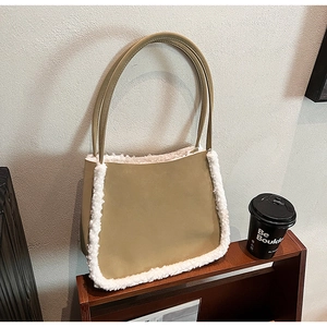 Khaki composite faux leather tote bag with white fleece trim in a modern urban setting