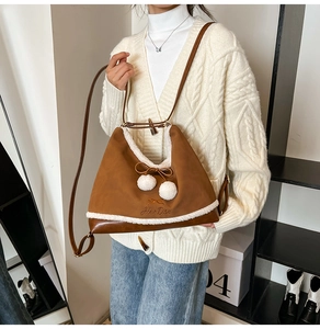 Detail of caramel frosted leather bag with plush trim and cute pom-pom bow decor